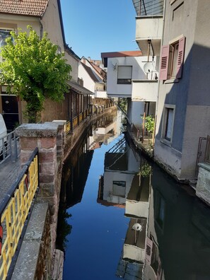A narrow canal flanked by buildings with a clear reflection in the water.