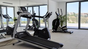 A gym with treadmills, a stationary bike, and a rowing machine. - Penthouse with luxury amenities, a rooftop terrace, and breathtaking views (Manilva)