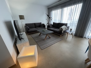 A modern living room with a sofa, coffee table, and a telescope.