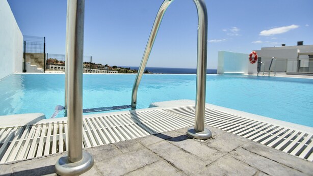 A poolside area with a clear view of the ocean, a lifebuoy, and a metal railing. - Penthouse with luxury amenities, a rooftop terrace, and breathtaking views (Manilva)
