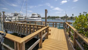 A wooden dock with boats docked at a marina. - Island getaway 3 minutes from sandy beaches. (Treasure Island)
