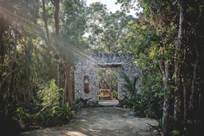 A rustic stone structure surrounded by dense forest.