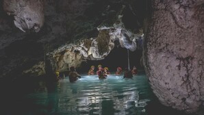 A group of people in a cave with water, some wearing helmets. - Wakax Hacienda - Cenote & Boutique Hotel - Small Luxury Hotels of the World (Tulum)