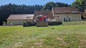 Un bâtiment rustique doté d’un toit en pente, d’un petit porche et d’un escalier menant à l’entrée.