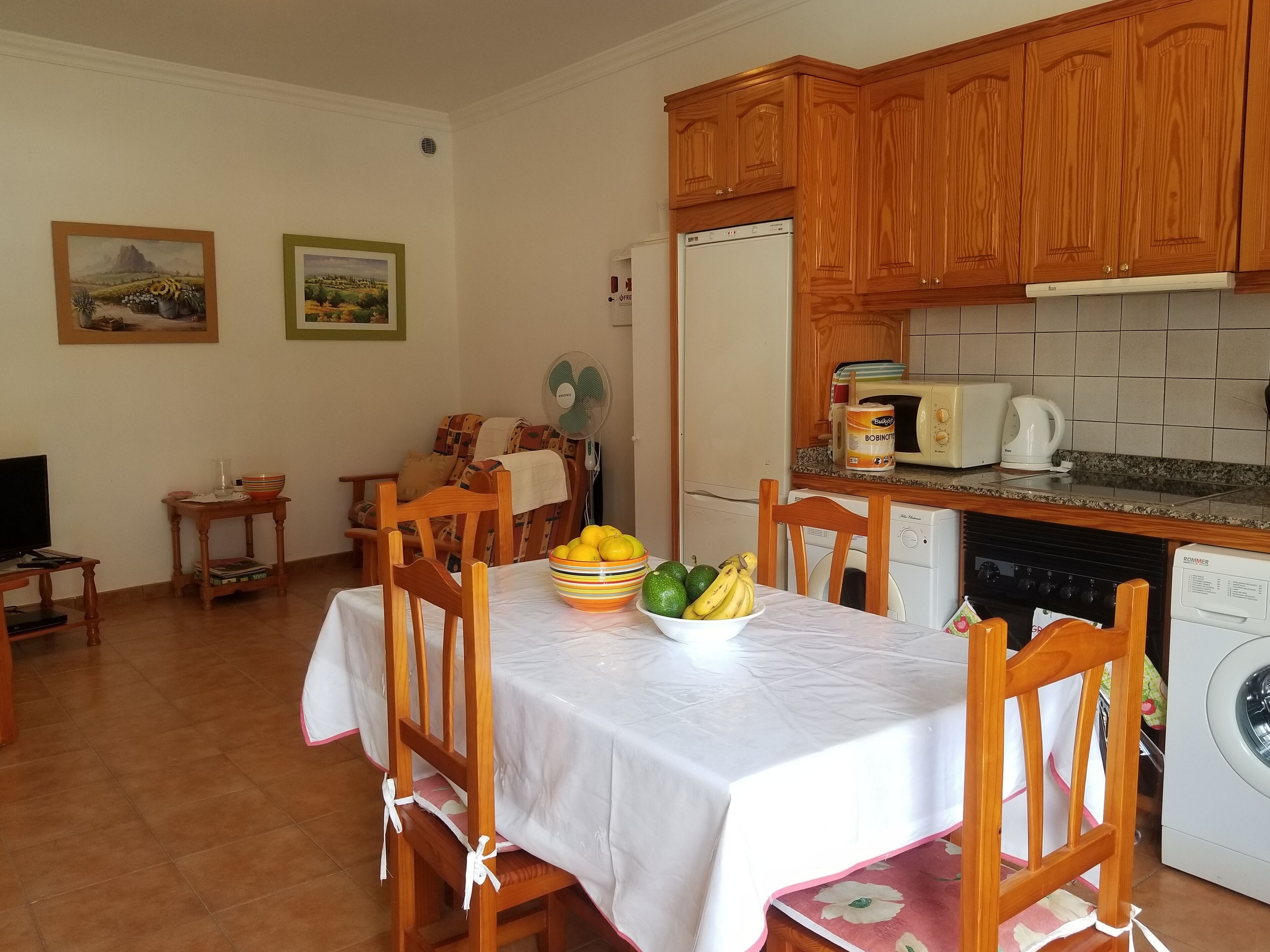 A compact living space with a dining area, kitchen, and a small seating area.