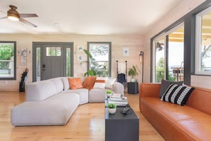 Ein modernes Wohnzimmer mit einem Ecksofa, einem Couchtisch und einem Ledersofa.