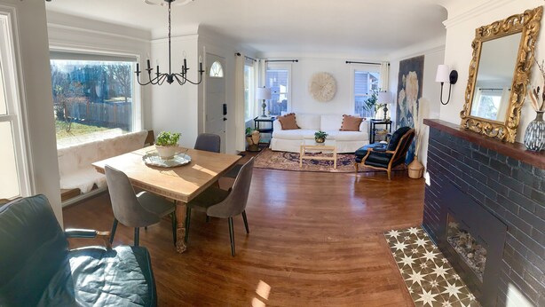 A spacious living room with a wooden dining table, a sofa, and a fireplace. - Swede Hill Suite (Moscow)