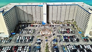 Korkea hotellirakennus, jossa on suuri pysäköintialue ja keskeisellä paikalla sijaitseva pyöreä aukio.