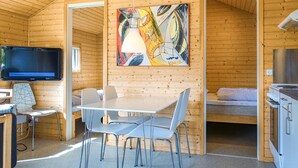 Ein gemütliches Blockhaus-Interieur mit Essbereich, Fernseher und einem Bild an der Wand.