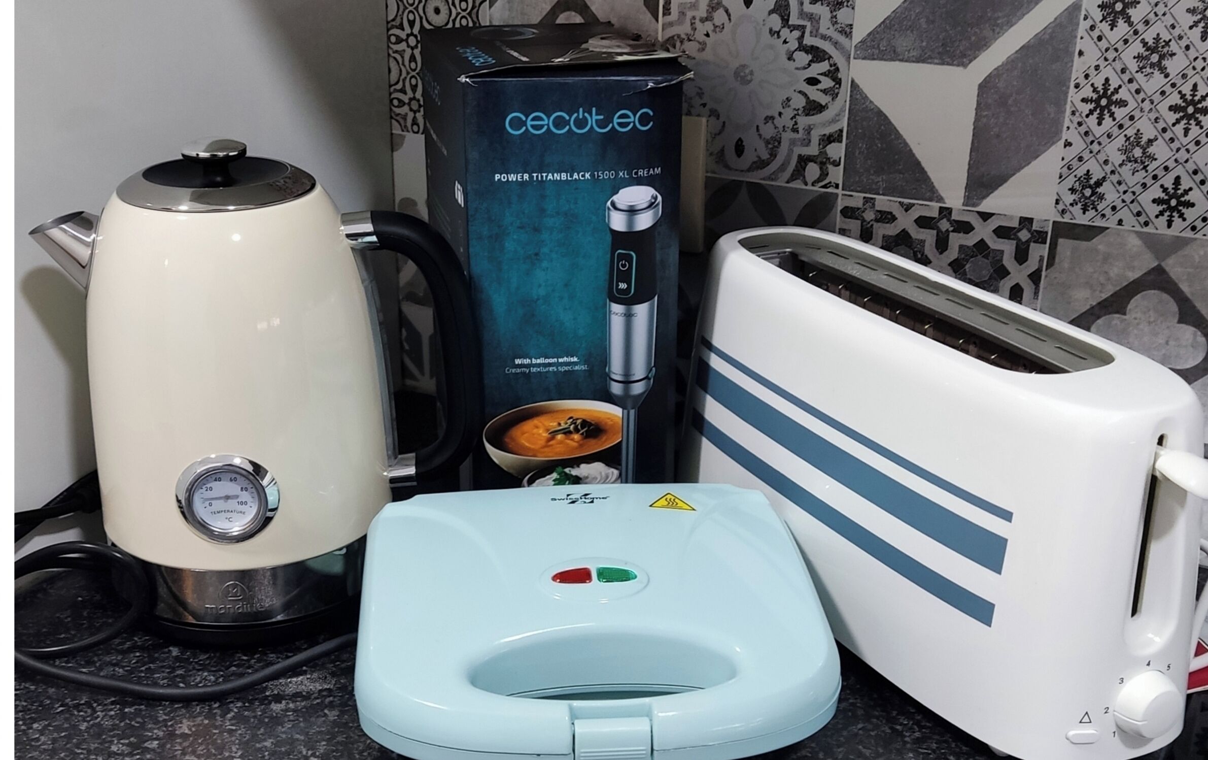 Eine Küche mit Wasserkocher, einer Packung Power Titanblack 1500 XL Cream und einem Toaster.