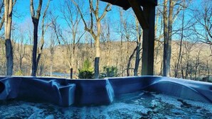 Een kamer met uitzicht op een bos en een waterlichaam.