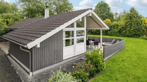A small, single-story house with a sloped roof, a covered porch, and a well-maintained garden. - 2 bedroom lovely home in Aabenraa (Aabenraa)