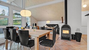 A modern kitchen with a large wooden table, black chairs, and a black stove. - 2 bedroom lovely home in Aabenraa (Aabenraa)