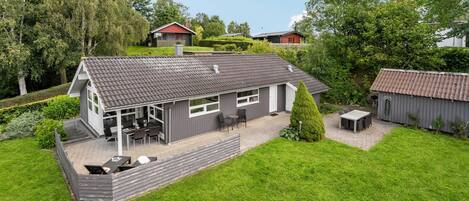 Enjoy outdoor dining or relaxation on the large patio surrounded by lush greenery and a well-maintained garden.
