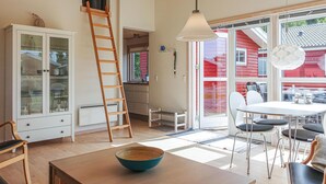 A bright, open-plan living space with a kitchen, dining area, and large windows. - Gorgeous home in Gudhjem with WiFi (Gudhjem)