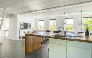 A modern kitchen with a large island, built-in appliances, and ample natural light. - Nice home in Allinge with kitchen (Allinge)