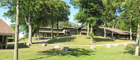 A campground with multiple cabins, trees, and a grassy area.