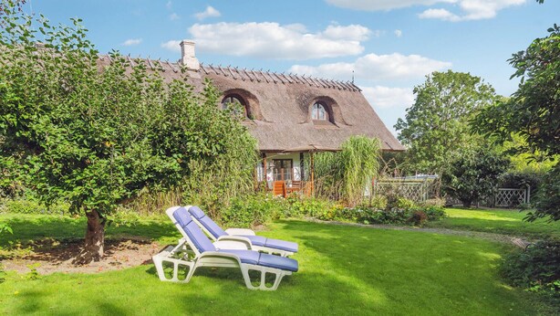 A thatched-roof house with a garden, including a lawn and a tree. - Nice home in Nexø with WiFi (Nexø)