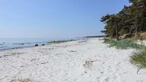 A sandy beach with a clear sky, a few scattered rocks, and some vegetation. - 3 bedroom gorgeous home in Nexø (Nexø)