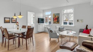 Un grand espace de vie comprenant une table à manger, des chaises, un canapé et un téléviseur.