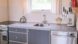 A kitchen with a stainless steel sink, a kettle, a coffee maker, and a dishwasher. - 2 bedroom awesome home in Allinge (Allinge)
