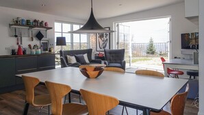 Una cocina moderna con comedor, ventanas amplias y vistas al exterior.