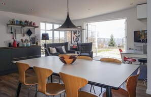 A modern kitchen with a dining area, large windows, and a view of the outdoors. - Gorgeous apartment in Allinge with WiFi (Allinge)