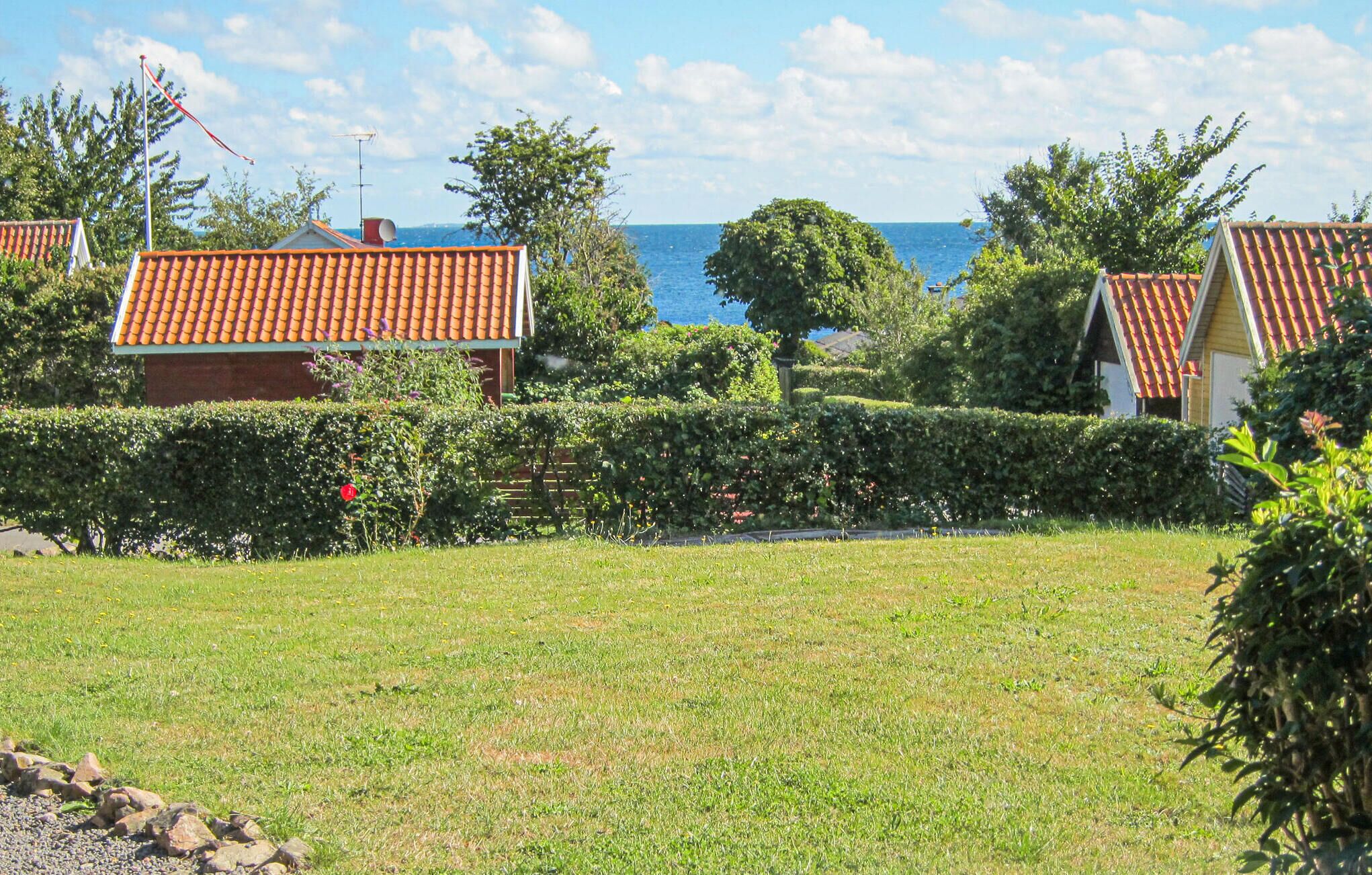 Un barrio residencial con casas, un campo cubierto de césped y vista al mar.