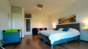 Quarto moderno com uma cama grande, um sofá e uma escrivaninha.