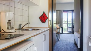 A compact kitchen with a Bosch coffee maker, a sink, and a window with a view of the outdoors.