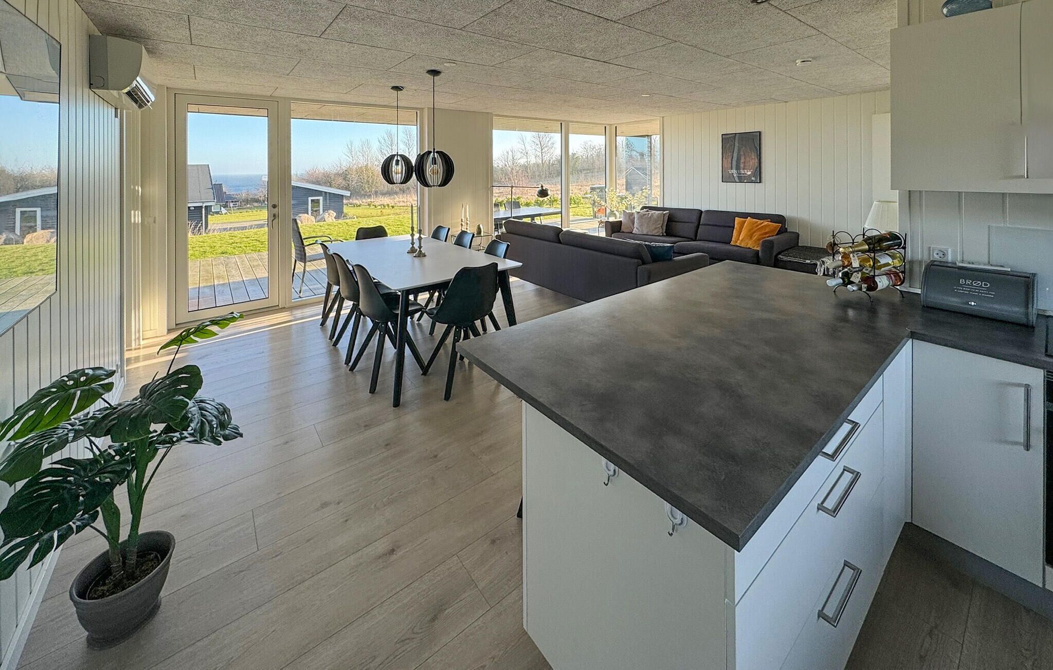 Een moderne keuken met een groot eiland, een eethoek met stoelen en een bank.
