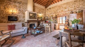 A rustic stone interior with a fireplace, wooden furniture, and a television. - 1 bedroom nice home in Siena (Siena)