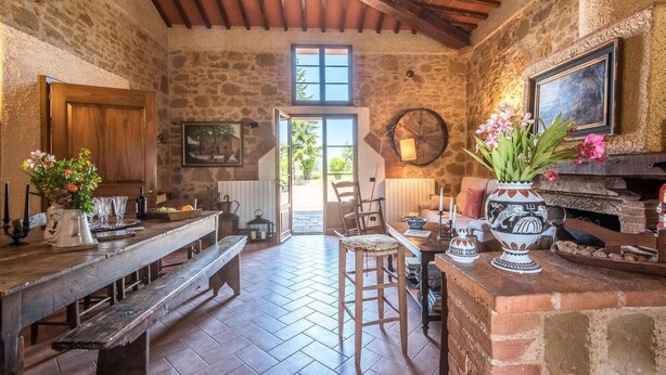 A rustic stone interior with a wooden bench, a table with a vase of flowers, and a fireplace. - 1 bedroom nice home in Siena (Siena)