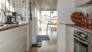 Eine Küche mit weißen Schränken, einer Kaffeemaschine und einer Holzausziehtafel.
