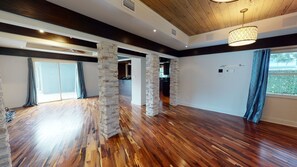 Enjoy a high ceiling with exposed beams and a chandelier, plus a balcony with views of the surrounding area.