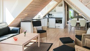 A loft-style apartment with a kitchen, dining area, and seating space. - 2 bedroom lovely apartment in Gudhjem (Gudhjem)