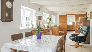 Uma sala de jantar com uma mesa, cadeiras e um relógio na parede.