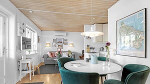 Un salón moderno con una mesa redonda, sillas color turquesa, un sofá gris y un mapa grande en la pared.