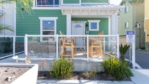 A two-story building with a green exterior, a sign indicating 'BEACH' and a permit parking sign. - 326 San Luis (Pismo Beach)
