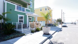 A row of colorful houses with a sidewalk and a parked car. - 326 San Luis (Pismo Beach)