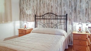 A bedroom with a bed, two nightstands, and a wooden dresser. - Cozy home in El Coronil (El Coronil)