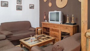 A living room with a brown sofa, a wooden coffee table, and a television on a wooden cabinet. - Cozy home in El Coronil (El Coronil)