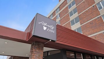 Welcome to the Allure Hotel, featuring a striking exterior with a prominent sign and modern architectural style.