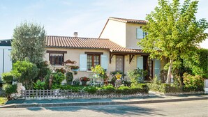 A two-story house with a tiled roof, a front garden with various plants, and a small pond. - Stunning home in Bergerac (Bergerac)