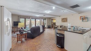 Un salón amplio con sofá, televisor y mesa de comedor.