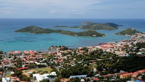 Vista aérea de un pueblo costero con varias islas pequeñas, aguas azules cristalinas y numerosos barcos.