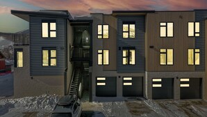 A modern multi-story residential building with multiple garage doors and large windows. - Welcome to Mountain Dreams + River Streams! (Silverthorne)