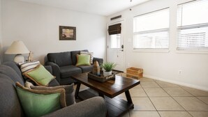 A living room with a sofa, armchairs, a coffee table, and a ceiling fan. - Emerald Shores: Steps from the Gulf, Navarre Beach (Navarre)