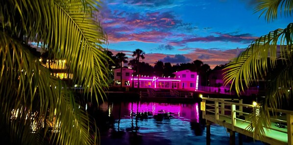 A waterfront hotel with a dock and palm trees. - The Mermaid Studio (New Port Richey)