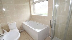 Une salle de bain moderne avec une baignoire, un lavabo et une douche.